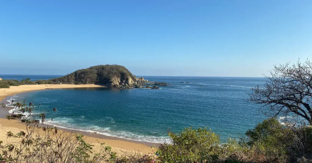 Playa de Puerto Escondido al atardecer con surfistas