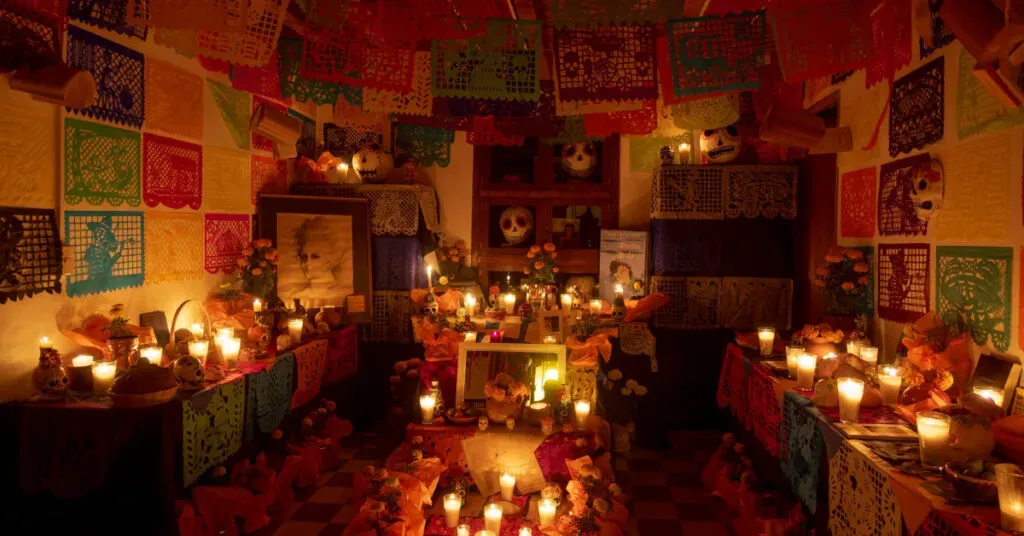 Altar de Día de Muertos decorado con velas y ofrendas en Oaxaca