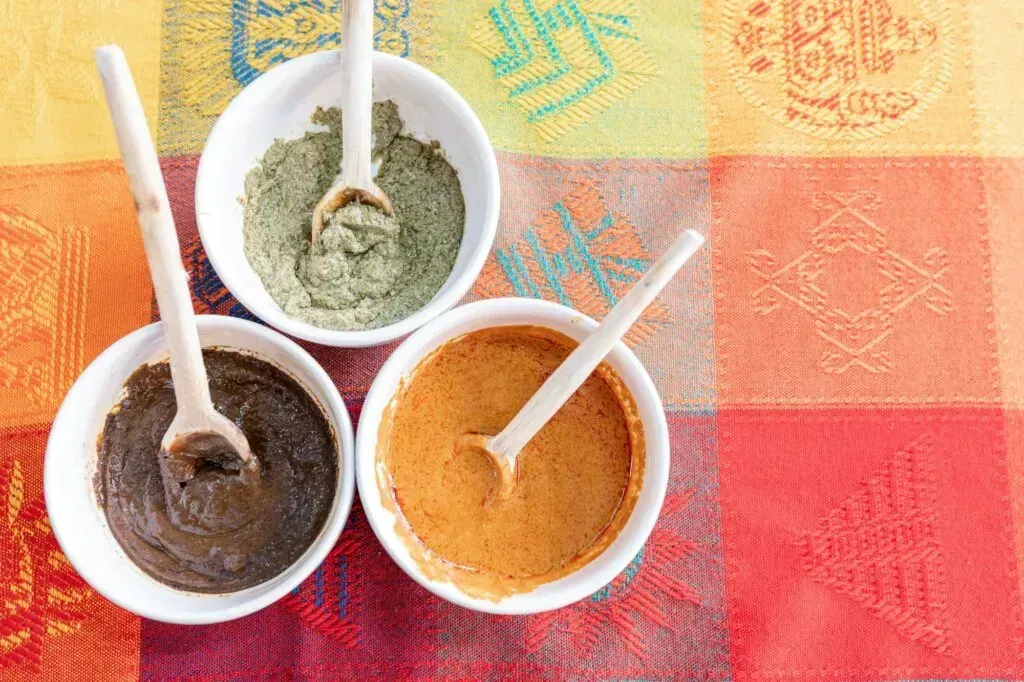 Tres variedades de mole oaxaqueño rojo, verde y amarillo en bowls